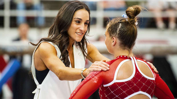 Arkansas coach Jordyn Wieber comforts a Razorback gymnast after a routine.